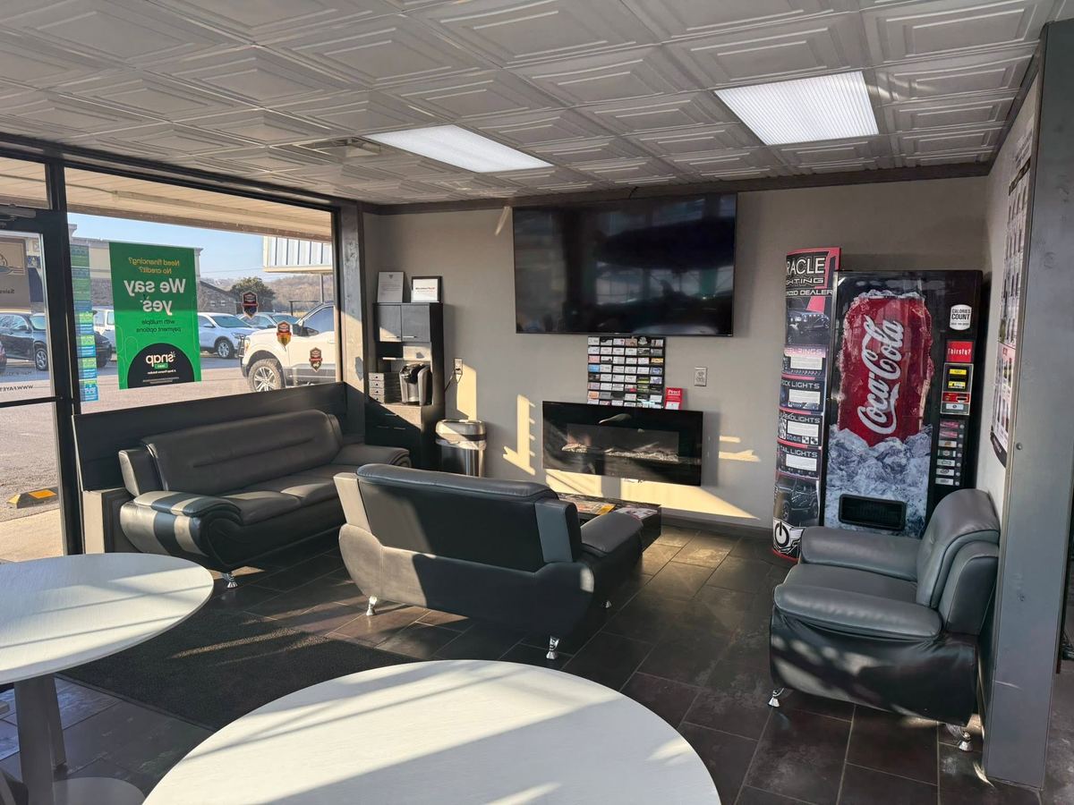 Fayetteville Automotive customer waiting area with comfortable seating and TV